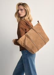 Beżowa zamszowa torebka shopper damska TORES-1248-1B(W26), widok produktu na ramieniu modelki. Widoczna połowa sylwetki.