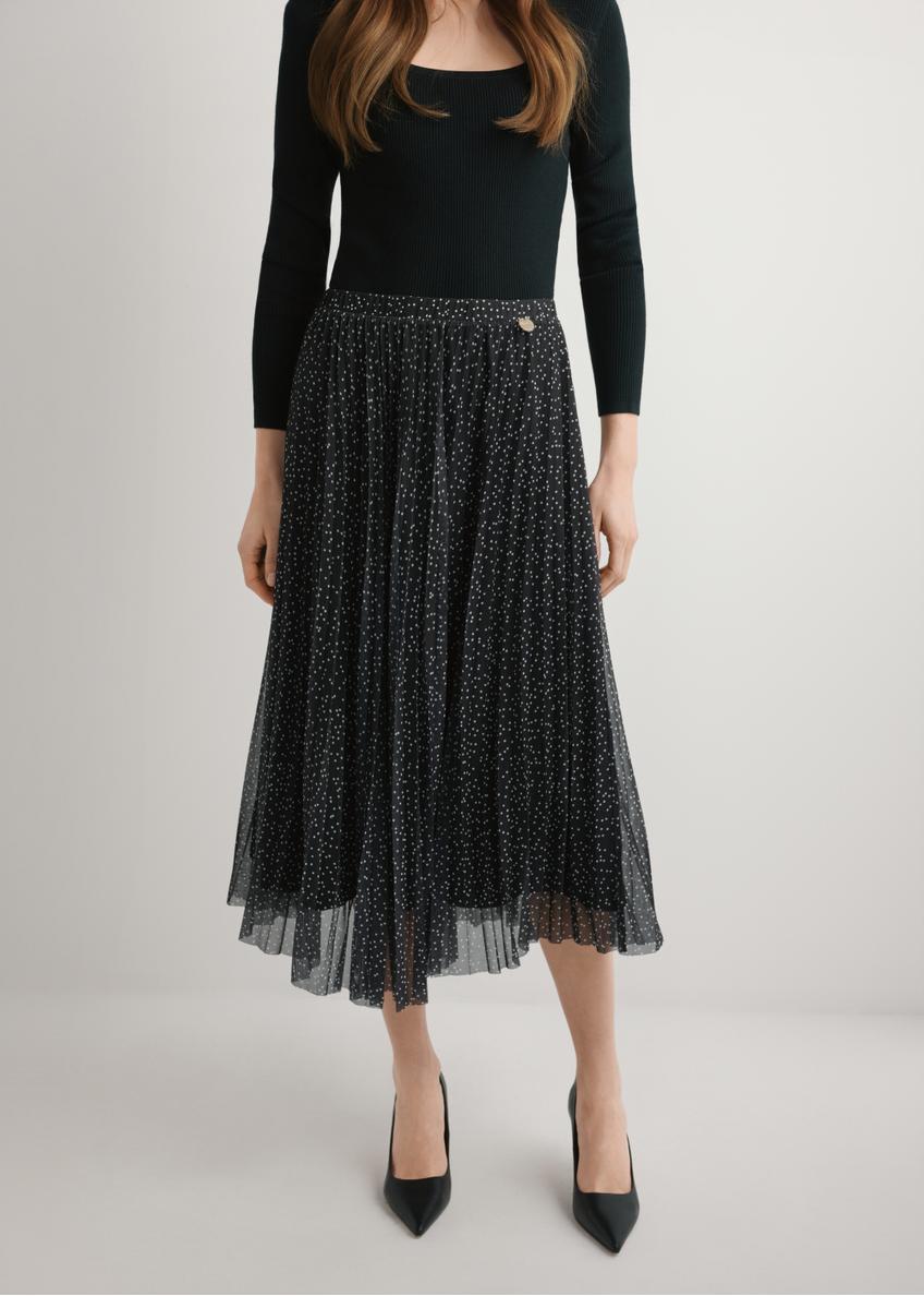 Spódnica plisowana midi w kropki SPCDT-0110-9P(W26), widok produktu od przodu na modelce, widoczna połowa sylwetki.