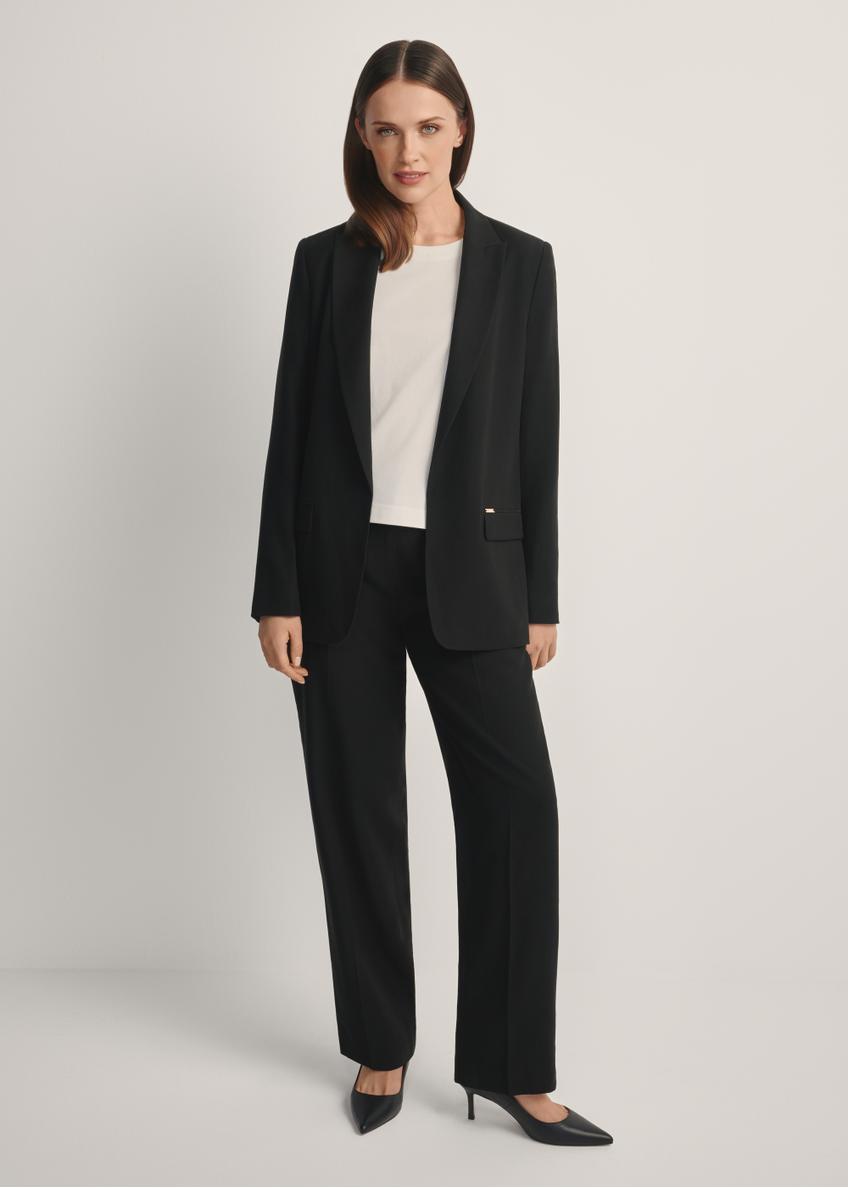 Czarne eleganckie spodnie damskie SPODT-0106A-99(W26), widok produktu od przodu na modelce, widoczna cała sylwetka.
